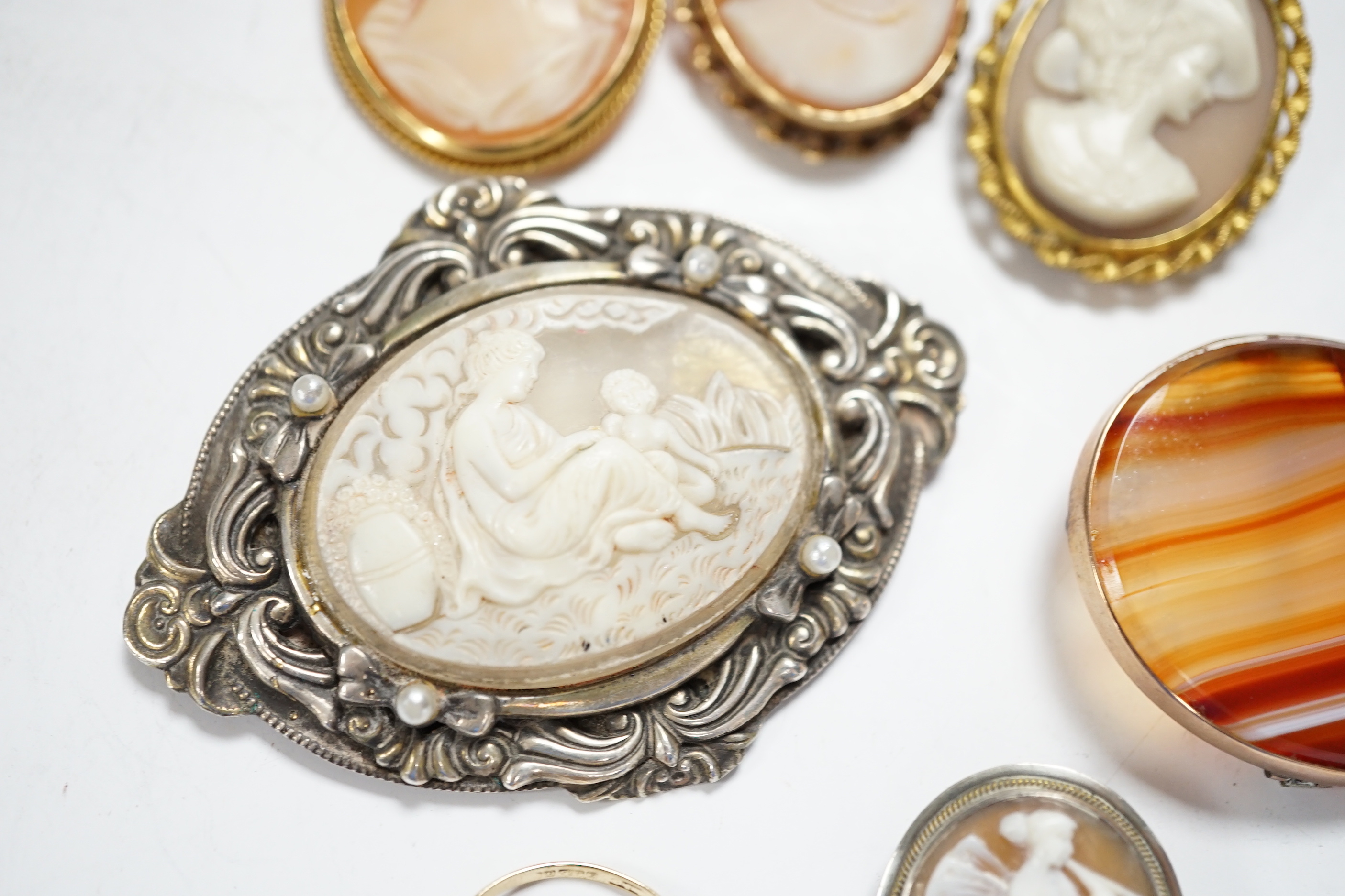 Two modern 9ct gold mounted oval cameo shell brooches, a 9ct gold and cameo shell set ring, three other cameo shell set brooches and a 9ct and banded agate set oval brooch, 40mm.
